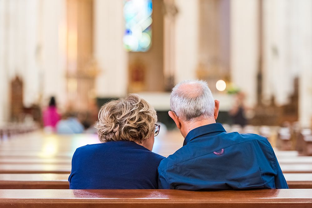 Back view of an elderly couple in the church.